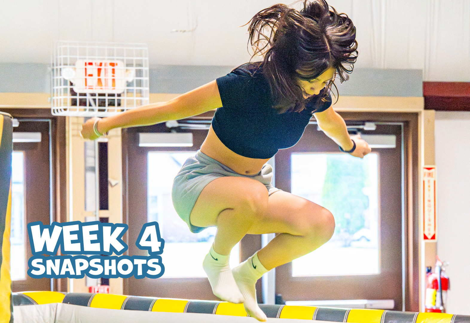 Person jumping indoors near double doors with exit sign and week 4 snapshots text visible.