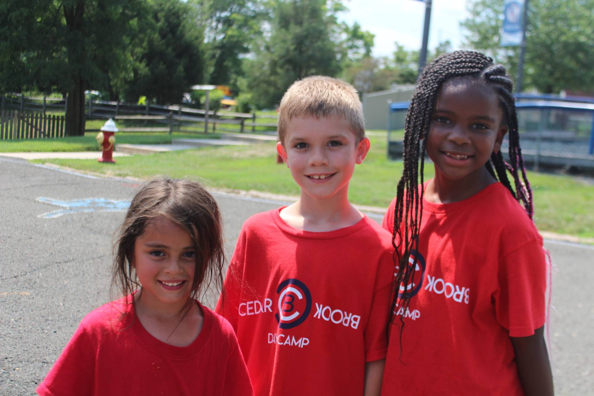 Three children in red shirts posing for a picture.