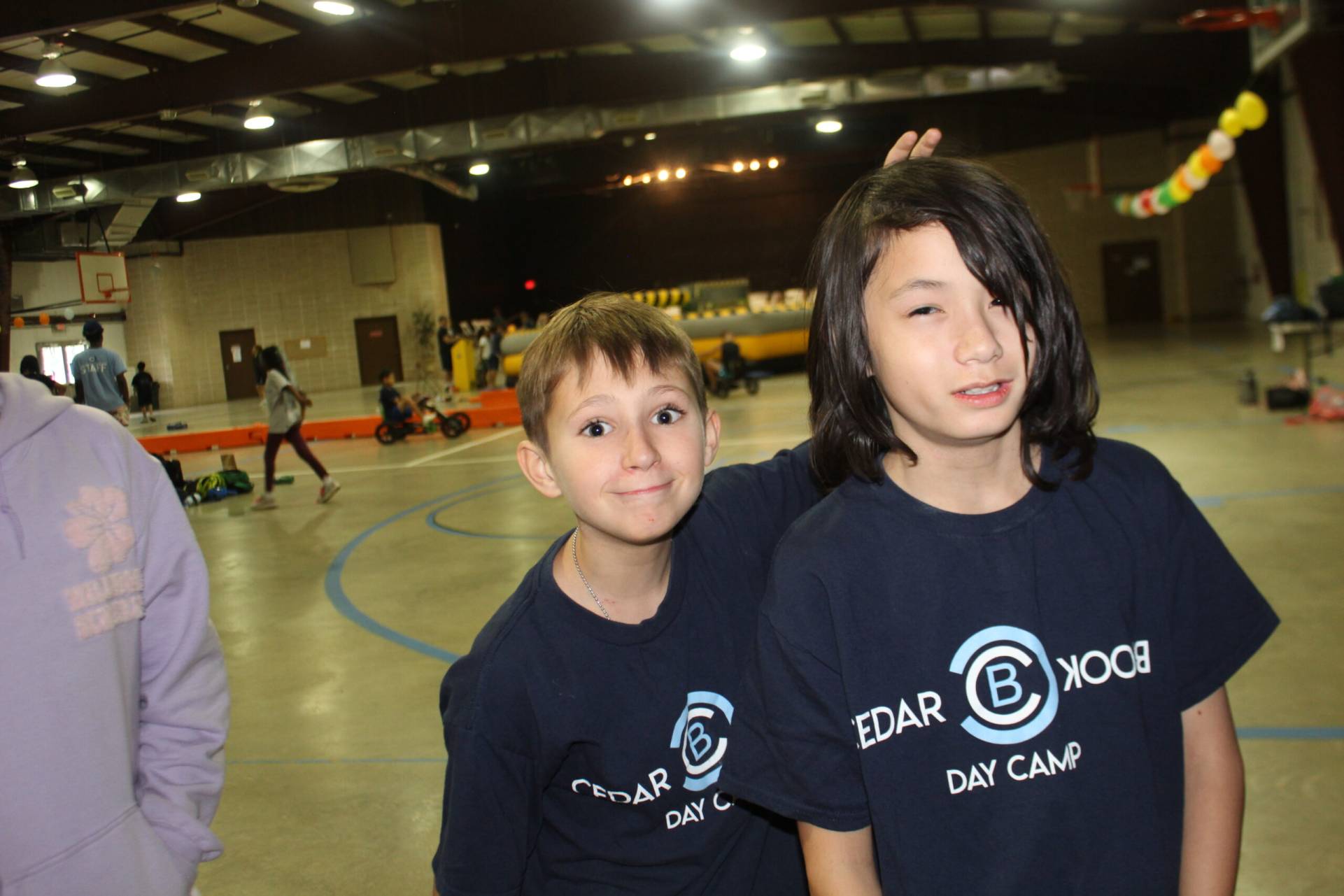 Two young boys in matching shirts pose for a picture.